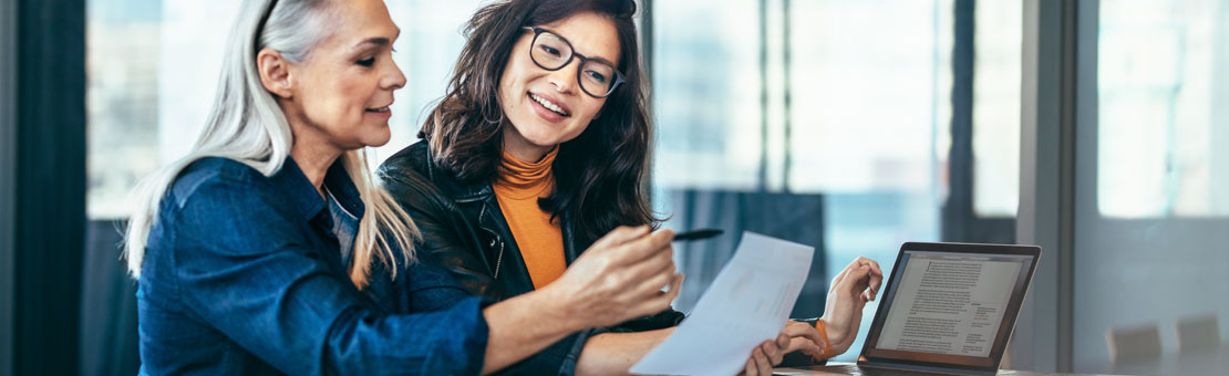 two women talking and looking at a piece of paper together