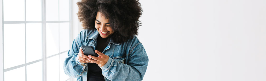 young woman smiling while using her mobile phone